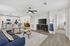 Bright and modern open-concept living space featuring a sleek kitchen with bar seating, cozy living area with stylish decor, and convenient access to bedroom.