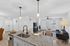 Bright and modern open-concept living space featuring a sleek kitchen island, elegant lighting, and a cozy living area with ample natural light.