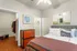 Chic bedroom with modern decor, featuring a comfortable bed, stylish wooden dresser, and spacious walk-in closet, perfect for a contemporary living experience.