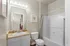 Modern bathroom with stylish lighting, elegant countertop, and a sleek bathtub featuring a neutral color palette.