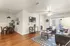 Inviting living and dining area with elegant hardwood floors, cozy seating, and abundant natural light through large windows.