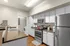 Modern kitchen with sleek stainless steel appliances, elegant white cabinetry, and warm wood flooring, perfect for culinary creativity.