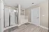 Elegant bathroom featuring a spacious glass-enclosed shower and cozy bathtub with modern decor.
