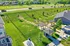 Vibrant aerial view of a lush community park with shaded seating areas, a modern play zone, and scenic pathways surrounded by greenery.