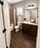 Elegant bathroom featuring modern fixtures, rich wooden cabinetry, and a bright atmosphere with stylish tile accents.
