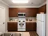 Modern kitchen with rich wooden cabinets, sleek countertops, and integrated appliances offering a warm, inviting atmosphere.
