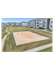 Contemporary apartment community with spacious green lawns and a well-maintained sand volleyball court, surrounded by modern residential buildings.