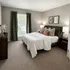 Inviting bedroom with plush bedding and elegant decor, featuring a large window with lush green views.