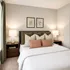 Cozy bedroom with elegant design featuring soft neutral tones, a plush bed, and stylish decor.