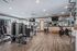 Modern fitness center with state-of-the-art exercise equipment, mirrored walls, and hardwood flooring.