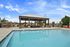 Luxurious outdoor pool area with elegant pergola and lounge seating, perfect for relaxation and entertainment.
