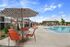 Inviting outdoor pool area with modern seating and stylish umbrella, ideal for relaxing on a sunny day.