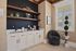 Chic coffee bar nook with modern cabinetry, elegant dark walls, and stylish decor, offering a cozy and inviting atmosphere.
