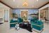 Chic lounge area with vibrant teal armchairs, stylish modern decor, and a striking cityscape mural creating a sophisticated ambiance.