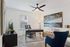Modern home office with stylish desk, blue accent chair, and large abstract artwork, creating a cozy and inviting workspace.