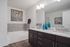 Elegant bathroom featuring a spacious counter space, dark wood cabinets, and a full size bathtub.