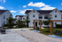 Charming townhouse community with modern architecture, lush green landscaping, and inviting outdoor seating areas, perfect for a serene lifestyle.