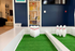 Chic recreational room featuring a stylish indoor bowling setup with green turf and modern shelving in a vibrant living space.
