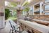 Charming outdoor grill area with stone countertops and seating, set in a beautiful apartment complex courtyard.
