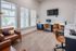 Bright and modern home office with large windows, stylish leather chairs, and sleek desk spaces.