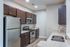 Modern kitchen featuring stainless steel appliances, sleek dark wood cabinets, and elegant granite countertops.