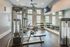 Modern fitness center with state-of-the-art gym equipment, including weights and cardio machines, enhanced by large windows and ample natural light.