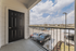Inviting balcony view showcasing a modern, secure railing overlooking a lively parking area and picturesque neighborhood skyline.