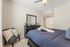 Cozy bedroom featuring plush bedding, elegant dresser with mirror, and stylish chair with accent pillows.