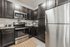 Modern kitchen with sleek stainless steel appliances, dark cabinetry, and elegant granite countertops.
