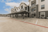 Modern apartment complex featuring covered parking, stylish exterior design, and well-maintained facilities under a bright blue sky.