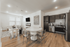 Modern open-concept apartment showcasing a chic kitchen, elegant dining space with a round table, and a stylish living area with contemporary decor.