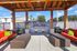 Inviting outdoor patio with cozy seating, vibrant cushions, and built-in BBQ grills under a rustic wooden pergola.
