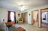Photo of our large apartment bedroom with bathroom, a sofa, rug, curtains, desk and computer