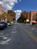 Charming urban street lined with colorful autumn trees and classic brick architecture under a vibrant blue sky.