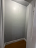 Versatile small space with sleek gray walls and warm wooden flooring, perfect for creative storage solutions.