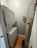 Compact laundry nook with stackable washer and dryer alongside a modern water heater, optimized for space efficiency.