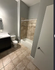 Modern bathroom with elegant tile flooring, a sleek bathtub, and a stylish vanity featuring ample lighting.
