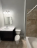 Modern bathroom featuring a sleek vanity, bright lighting, and a stylish tile bathtub.