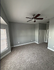 Bright and airy room with plush carpet, modern ceiling fan, and neutral walls, perfect for a stylish bedroom or relaxing living space.