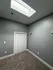 Bright and inviting room with a modern skylight, plush carpeting, and ample closet space.