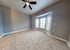 Spacious, sunlit bedroom with plush carpeting and elegant bay window, perfect for creating a cozy retreat.