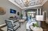 Elegant apartment lounge with stylish decor, featuring a modern chandelier, cozy seating area, and ambient lighting.