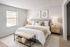 Bright and cozy bedroom featuring a plush king-size bed with soft beige accents, stylish nightstands, and elegant decor.