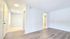 Bright and inviting apartment interior featuring modern wood flooring and elegant white walls, creating a spacious and airy ambiance.
