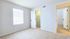 Bright bedroom with plush carpet, large window, and walk-in closet, offering spacious comfort and modern appeal.