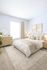 Bright and elegant bedroom filled with natural light, featuring a cozy bed with soft linens, stylish wooden furniture, and tasteful decor perfect for tranquility and relaxation.