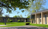 Charming modern apartment complex with well-maintained green lawns and mature trees, now leasing.