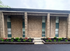 Charming brick apartment facade with lush landscaping and modern architectural details.