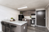 Modern kitchen with sleek granite countertops, elegant cabinetry, and bar seating, offering a perfect blend of style and functionality.