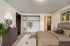 Inviting bedroom with plush carpeting, sleek dresser, and a spacious open wardrobe complemented by modern decor.